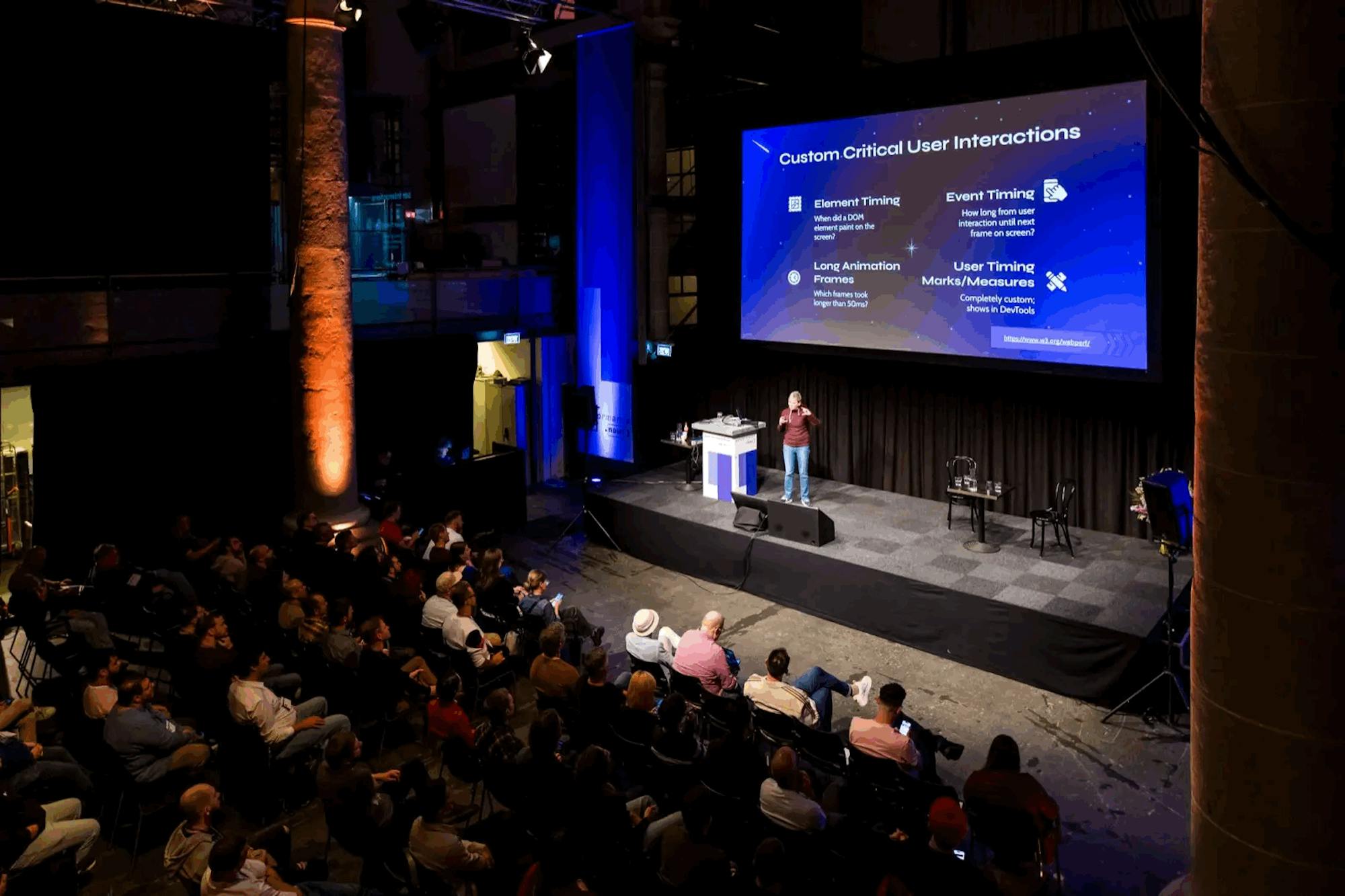 Women on stage presenting at a performance conference